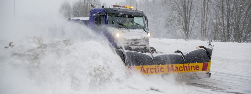 Lumiaura auraa lunta maantiellä.