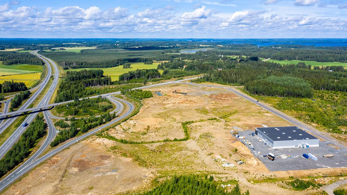 Ilmakuva teollisuusalueesta, alakulmassa yksi rakennus, muuten tyhjä kenttä
